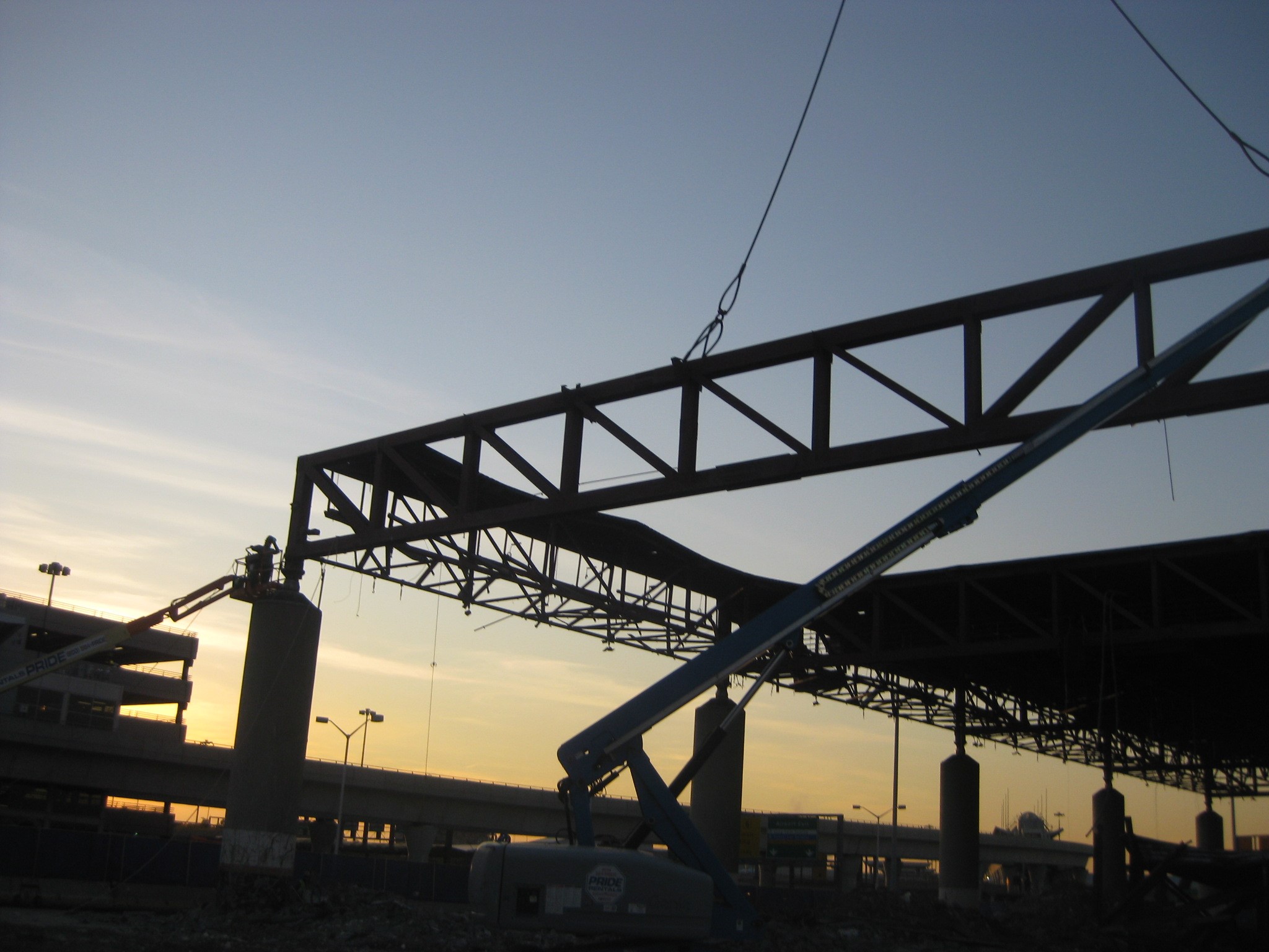 Image of worker assisting with large framing load being moved by crane